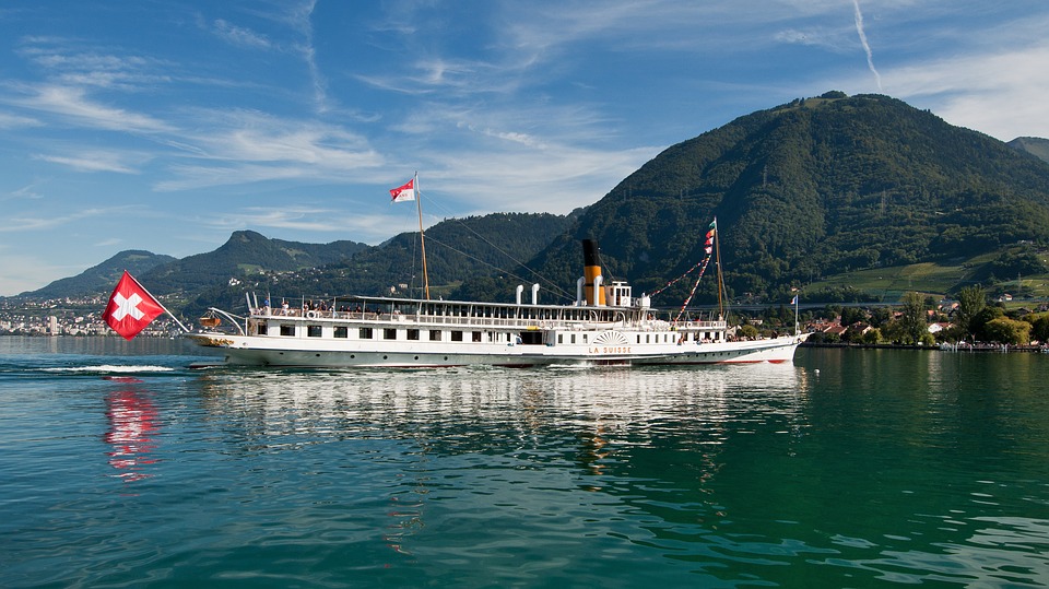 bateau sur lac avec drapeau suisse et montagne